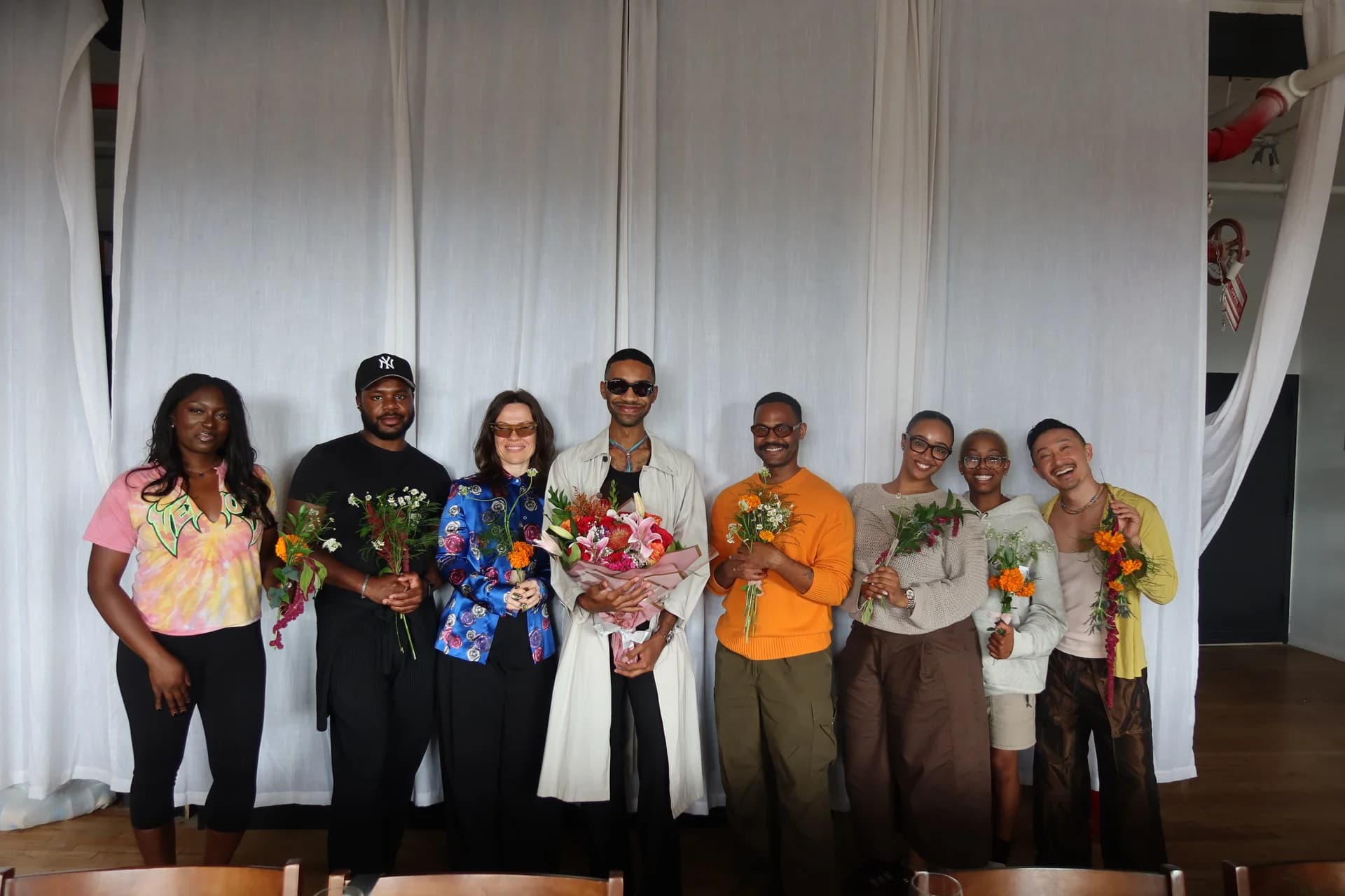 The group with flowers and arrangements at the close of the gathering.